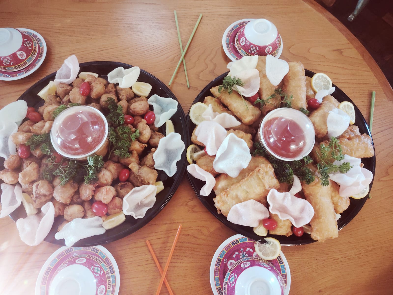 Two Golden Bowl sharing platters of golden fried chicken, spring rolls and prawn crackers