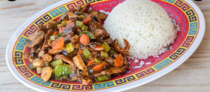 Black bean stir fry with peppers, mushrooms and carrots served with steamed rice