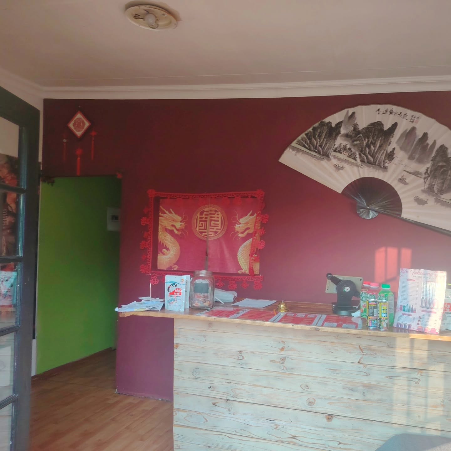 Inside Golden Bowl Asian & Sushi Bar with the wooden counter and Chinese fan decor